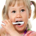 Close up portrait of cute girl brushing teeth.
